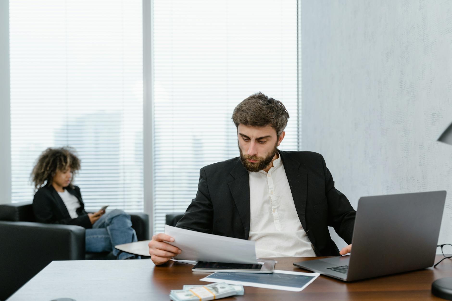 man in black suit jacket analyzing data reports